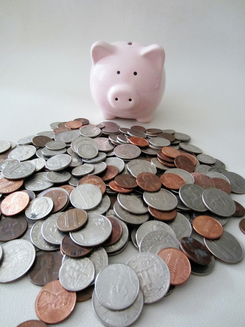 Piggy atop mountain of glistening coins