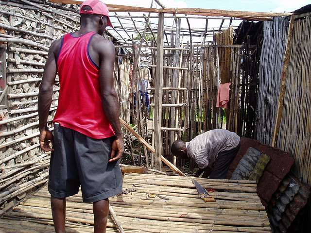 People constructing a bamboo house